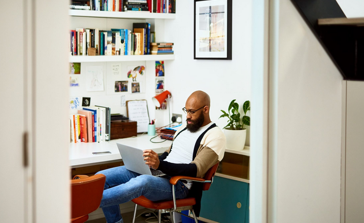 A Picture of a Black Man Sitting in an Office Surrounded by Diffent Books 